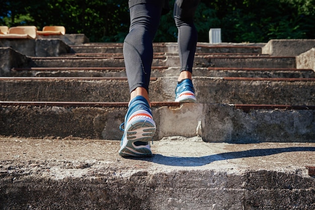 Male sprinter wearing running shoes at concrete stairs background sport and fitness runner athlete t