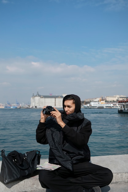 Male tourist taking photos with camera during trip