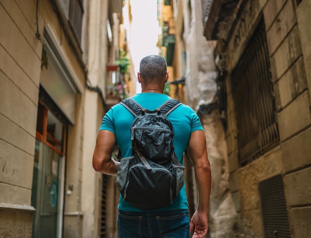 Male tourist walking in old town alley Barcelona Spain