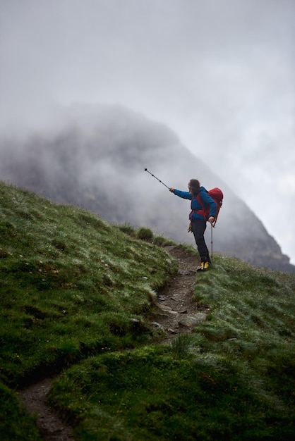 Male traveler standing on grassy hill