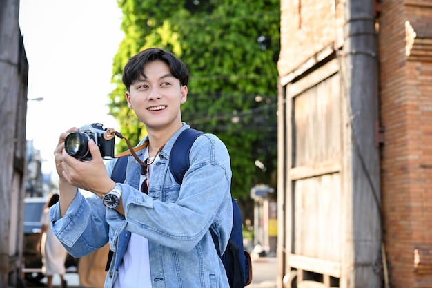 male traveler or tourist taking a picture by his retro camera while strolling around the old city