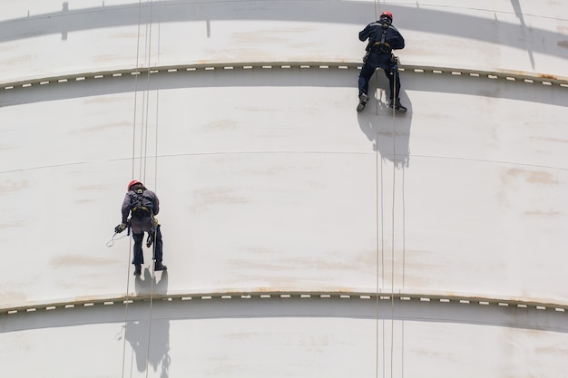 Male two worker rope access  inspection of thickness storage  white tank industry