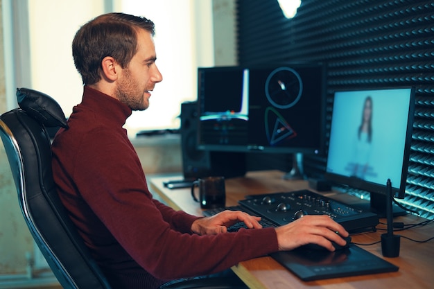 Male Videographer Edits and Cuts Footage and Sound on His Personal Computer