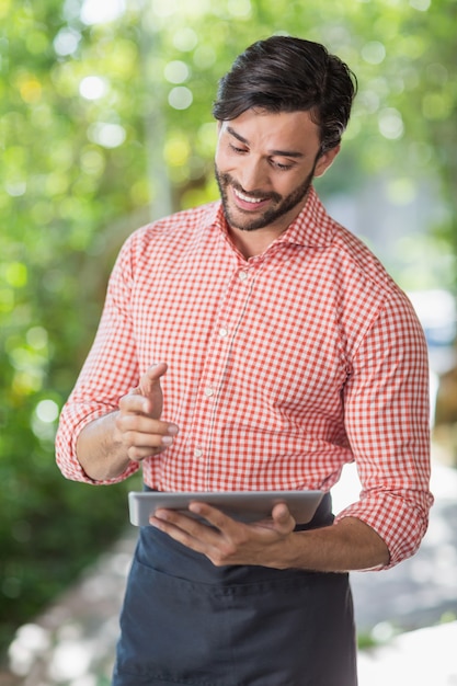 Male waiter using digital tablet