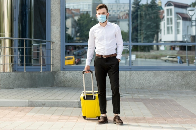 Male with luggage wearing mask