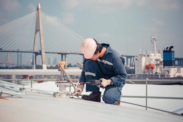 Male worker are ultrasonic thickness roof of storage tank