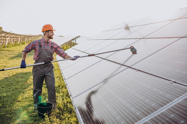 Male worker cleaning solar panels