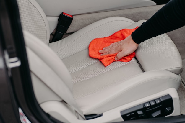 Male worker cleans car seat