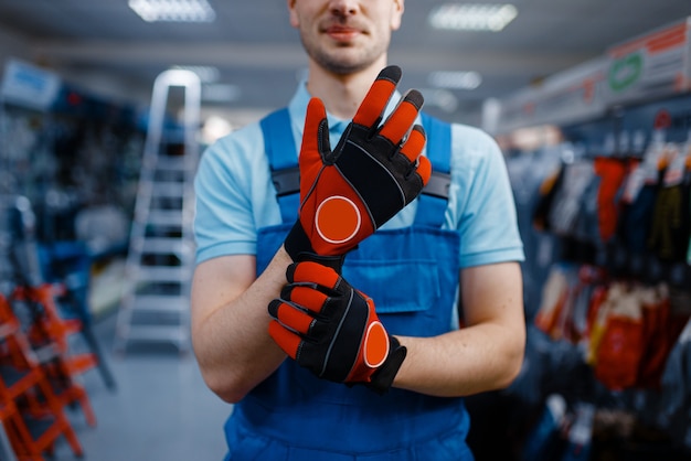 Male worker hands in protective gloves, tool store