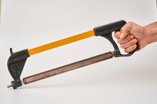 Photo male worker holding a metal cutting saw on an isolated background