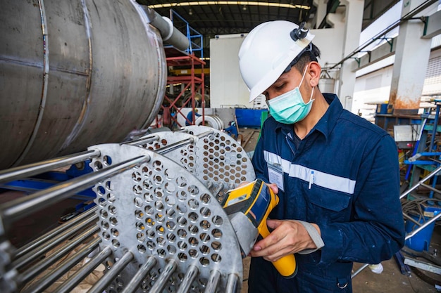 Male worker inspecting surface on heat exchanger tube bundle industrial construction warehouse positive