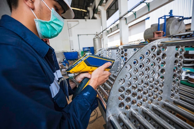 Male worker inspecting surface on heat exchanger tube bundle industrial construction warehouse positive