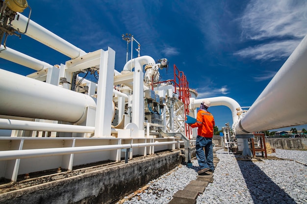 Male worker inspection at steel long pipes and pipe elbow in station oil factory during refinery valve of visual check record pipeline oil and gas industry