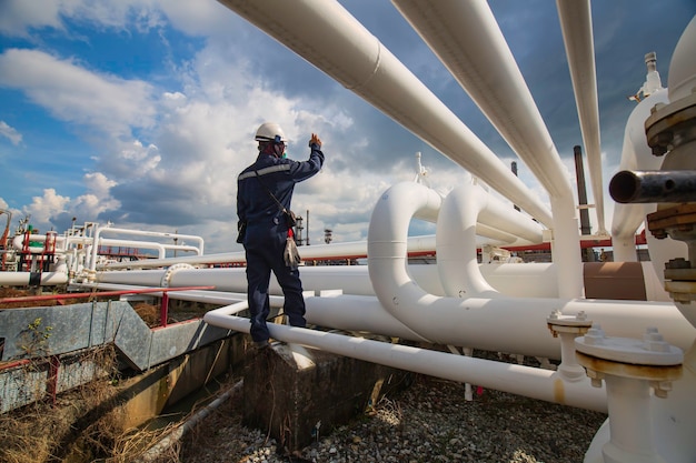 Male worker inspection at steel long pipes and pipe elbow in station oil factory during refinery valve of visual check record pipeline oil and gas industry.