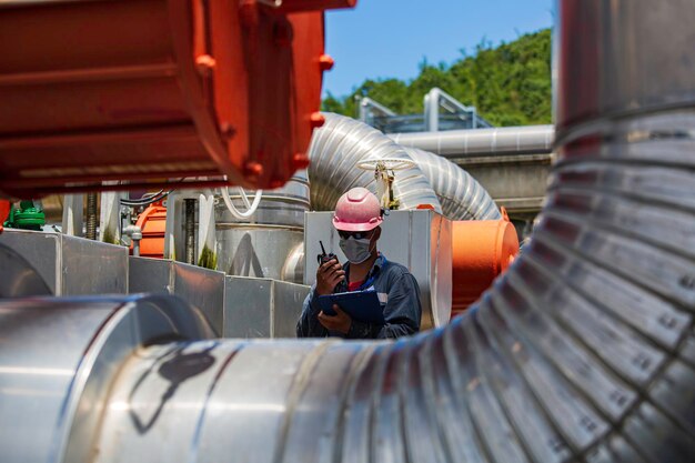 Male worker inspection at steel long pipes and pipe elbow in station oil factory during refinery valve of visual check record pipeline oil and gas