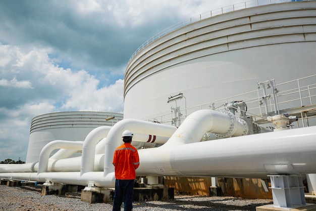 Male worker inspection at steel long pipes and pipe elbow in station oil factory during refinery valve of visual check record pipeline tank oil