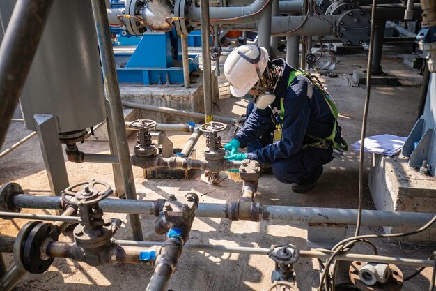 Male worker inspection at steel long pipes and pipe elbow in station oil factory during refinery valve of visual check record pipeline