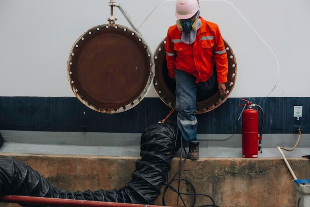 Male worker into the tank carbon chemical oil interface area confined