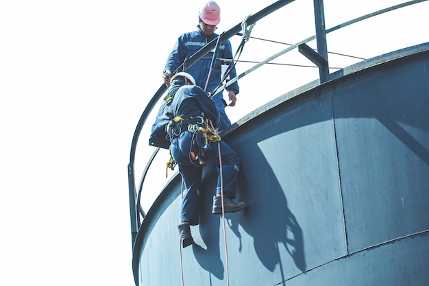 Photo male worker rope access height safety inspection of thickness storage oil and gas tank industry