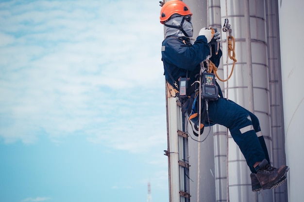 Male worker rope access inspection of thickness storage tank