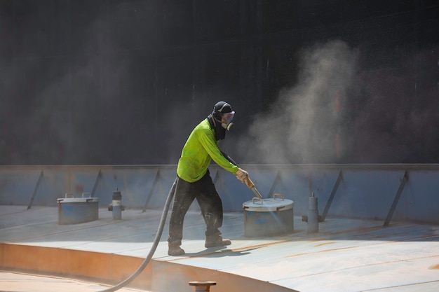 Male worker surface corrosion plate preparation by sand blasting of tank top deck pontoon