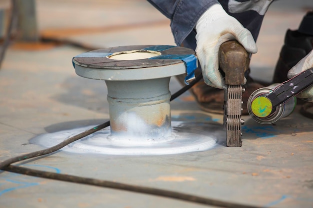 Male worker test nozzle tank butt weld carbon roof plate of storage tank oil background white contrast of magnetic field