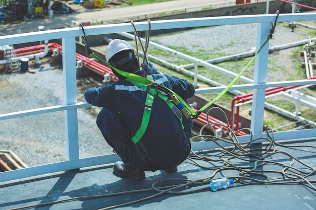 Male worker wearing safety first harness and safety lone working at high handrail