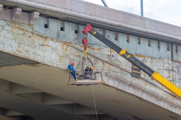 Male workers repairing a bridge