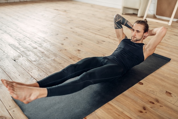 Male yoga in class, press training