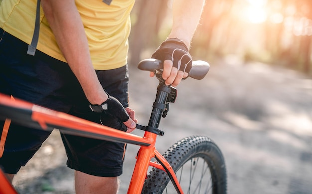 Man adjusting bicycle seat height