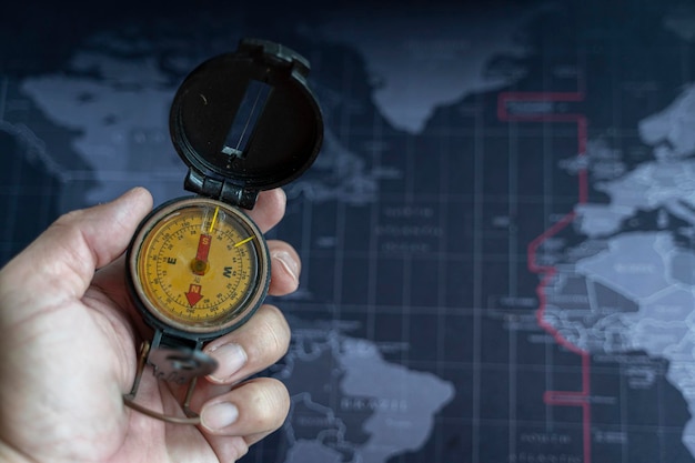 Man on an adventure is holding a compass in his hand for finding is route