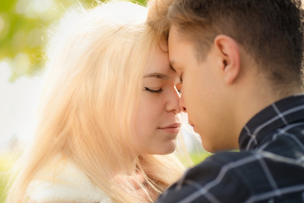 A man affectionately call looks at woman, guy and girl are worth close, touching tips noses