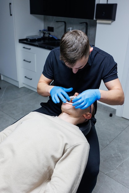 A man at an appointment with an orthodontist orthodontic treatment of teeth Modern medical orthodontic office Dental care