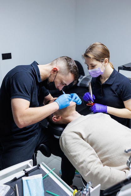 A man at an appointment with an orthodontist orthodontic treatment of teeth Modern medical orthodontic office Dental care