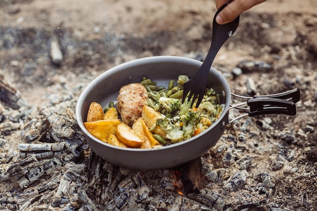 Man are heated in a fire and cook out on a summer camp