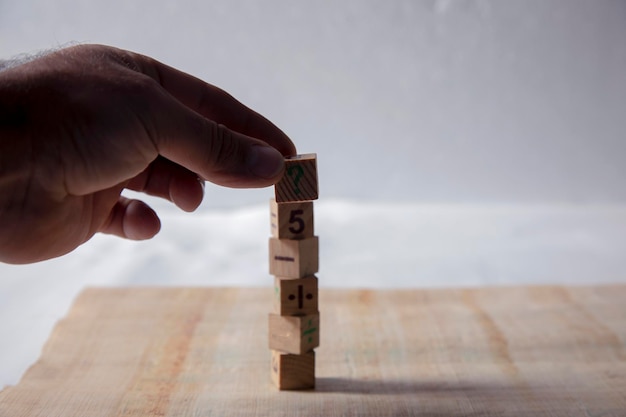 Man arranges the number wood cubes