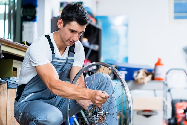 Man as bicycle mechanic working in workshop