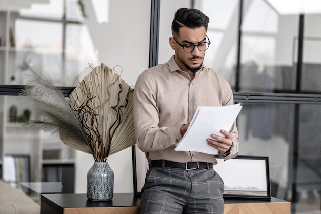 Man attentively looking at papers standing at home