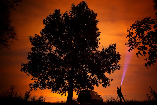 The man on the background of bright stars of the night cloudy sky.