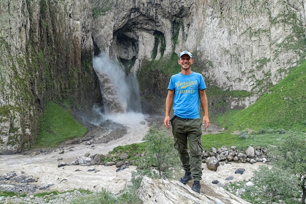 A man on the background of the TuzlukShapa waterfall on the territory of KabardinoBalkaria Caucasian Russia