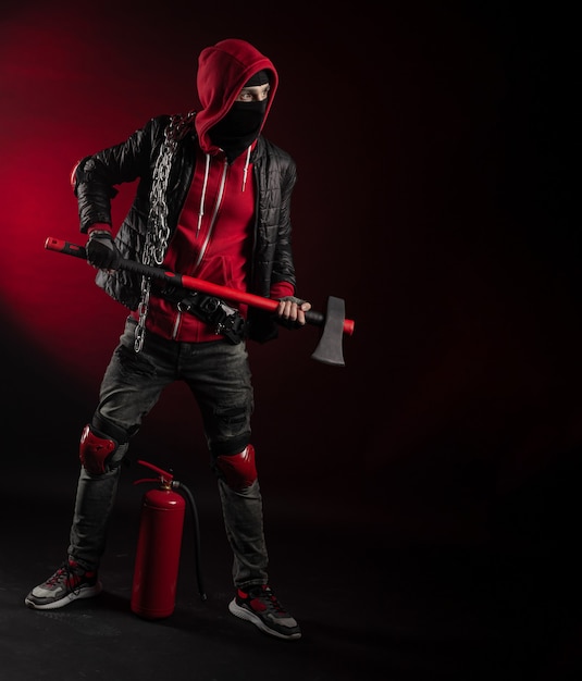 The a man in a Balaclava and hoodie with an axe and a fire extinguisher the image of a Protestant