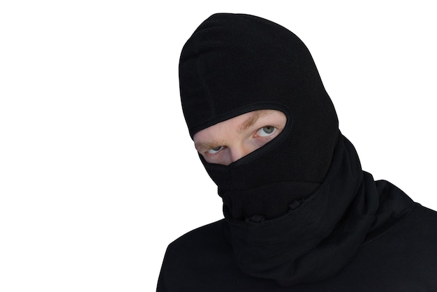 Man in balaclava looks suspiciously close-up portrait isolated on a white wall