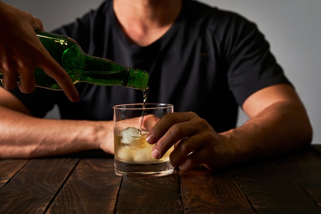 Man at a bar drinking alcohol. Concept of alcoholism and drinking addiction.