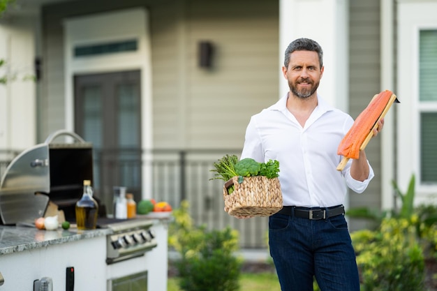 Man at a barbecue grill chef cook preparing barbecue salmon fillet outdoors bbq salmon grill for