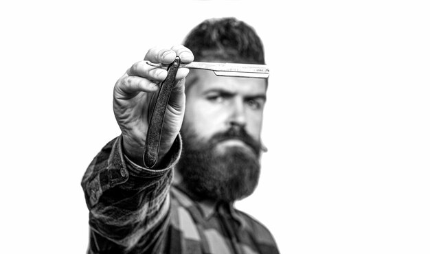 Man in barbershop Handsome bearded hairdresser is holding a straight razor while barbershop Vintage straight razor Mens haircut Black and white