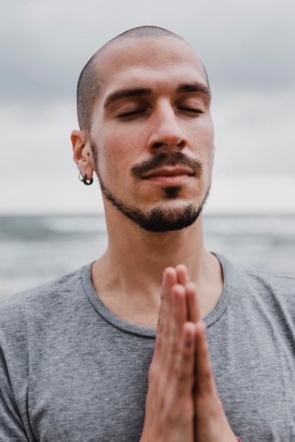 Photo man on the beach practicing yoga contemplation