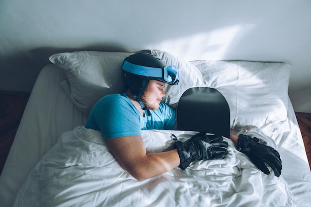 Man in bed with snowboard ski googles and helmet