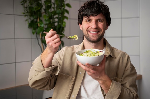 Man in a beige shirt eating a vegetable salad for lunch the concept of healthy eating and lifestyle