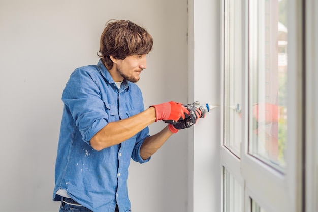 Man in a blue shirt does window installation