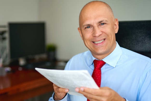 Man in blue shirt and red tie at office